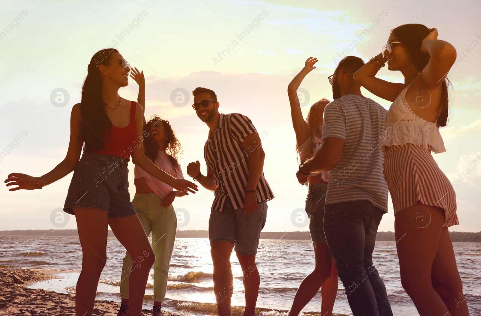 Photo of Group of friends having fun near river at summer party