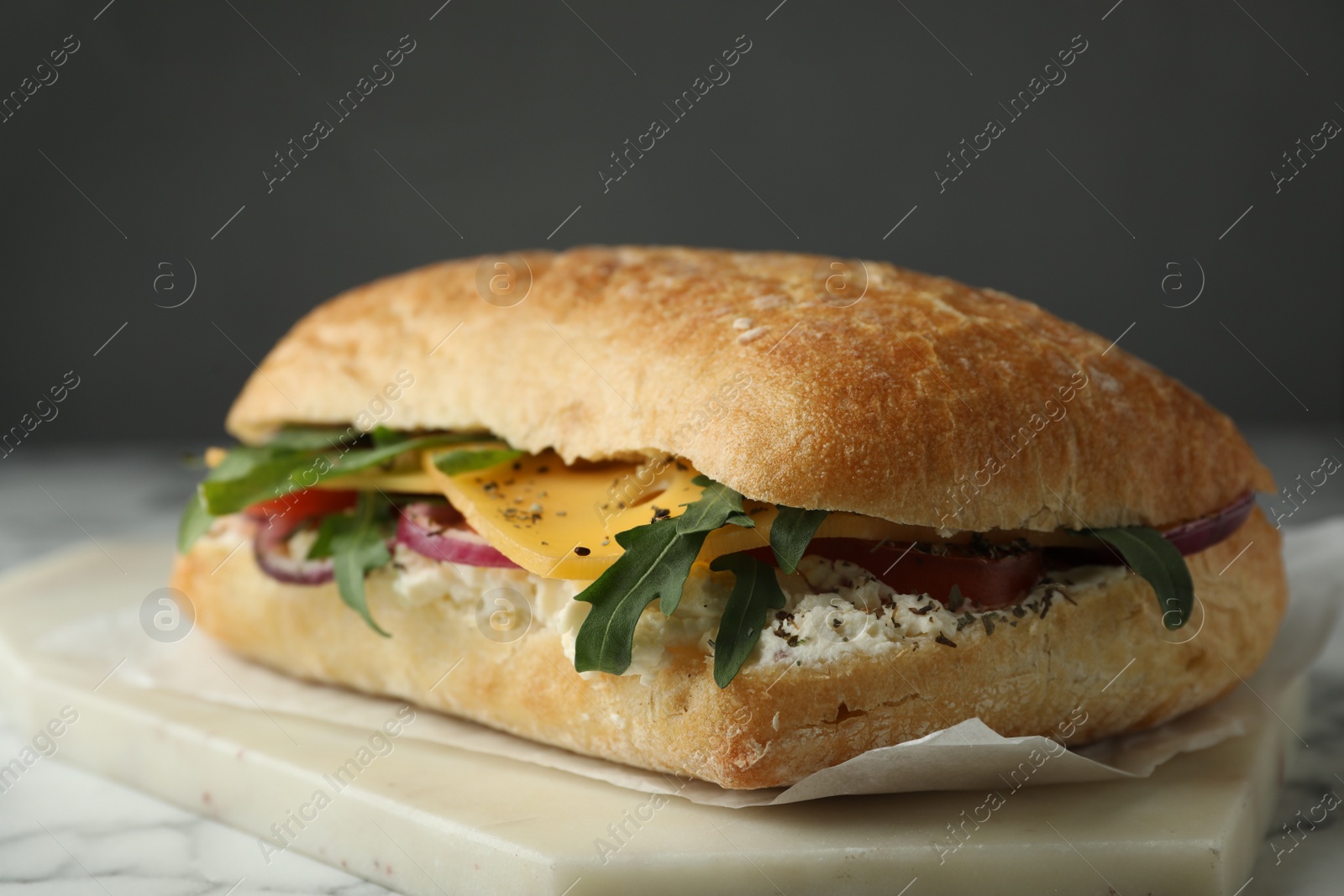 Photo of Delicious sandwich with fresh vegetables and cheese on white marble table