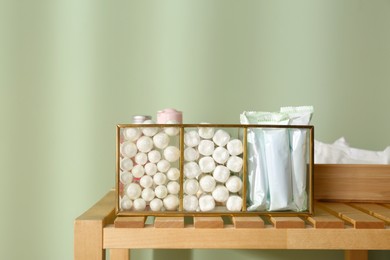 Organizer with many tampons on wooden table against light green background. Menstrual hygienic product