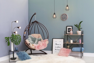 Photo of Elegant living room interior with hanging armchair and fuzzy rug