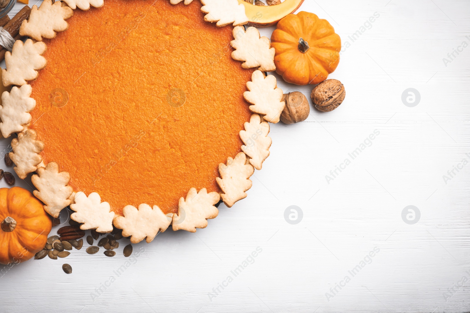 Photo of Delicious homemade pumpkin pie on white wooden table, flat lay. Space for text