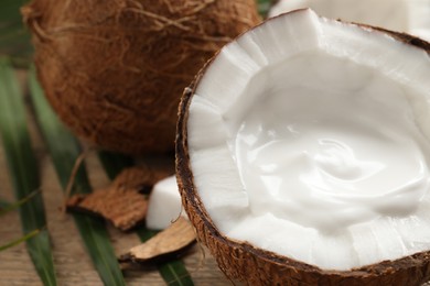 Photo of Ripe coconut with cream on table, closeup. Space for text