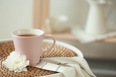 Photo of Cup of tea and flower on table indoors