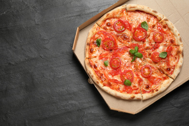 Photo of Delicious pizza Margherita on dark grey table, top view. Space for text