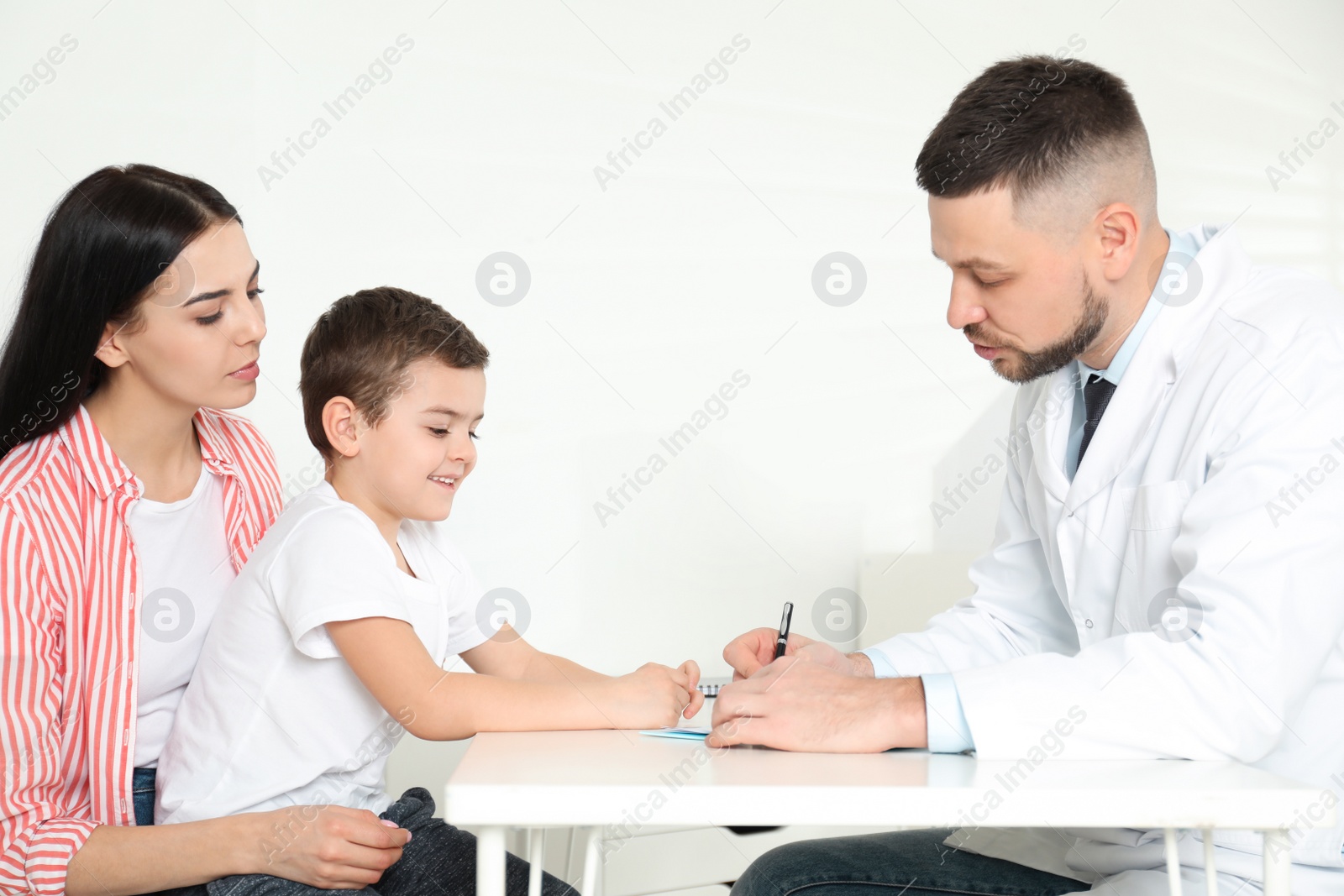 Photo of Little boy with mother visiting orthopedist at clinic