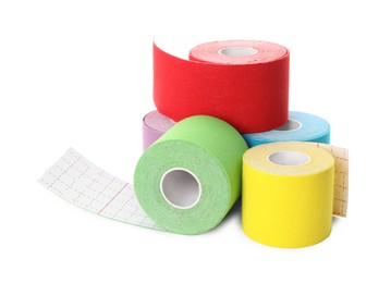 Photo of Many bright kinesio tape in rolls on white background
