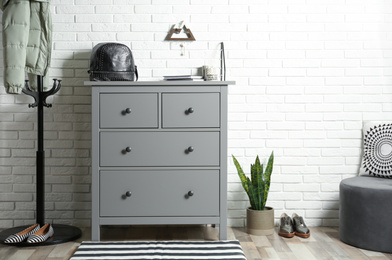 Photo of Grey chest of drawers in stylish hallway interior