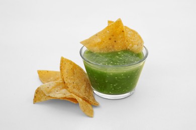 Tasty salsa sauce and tortilla chips on white background
