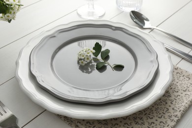 Photo of Stylish setting with cutlery and plates on white wooden table