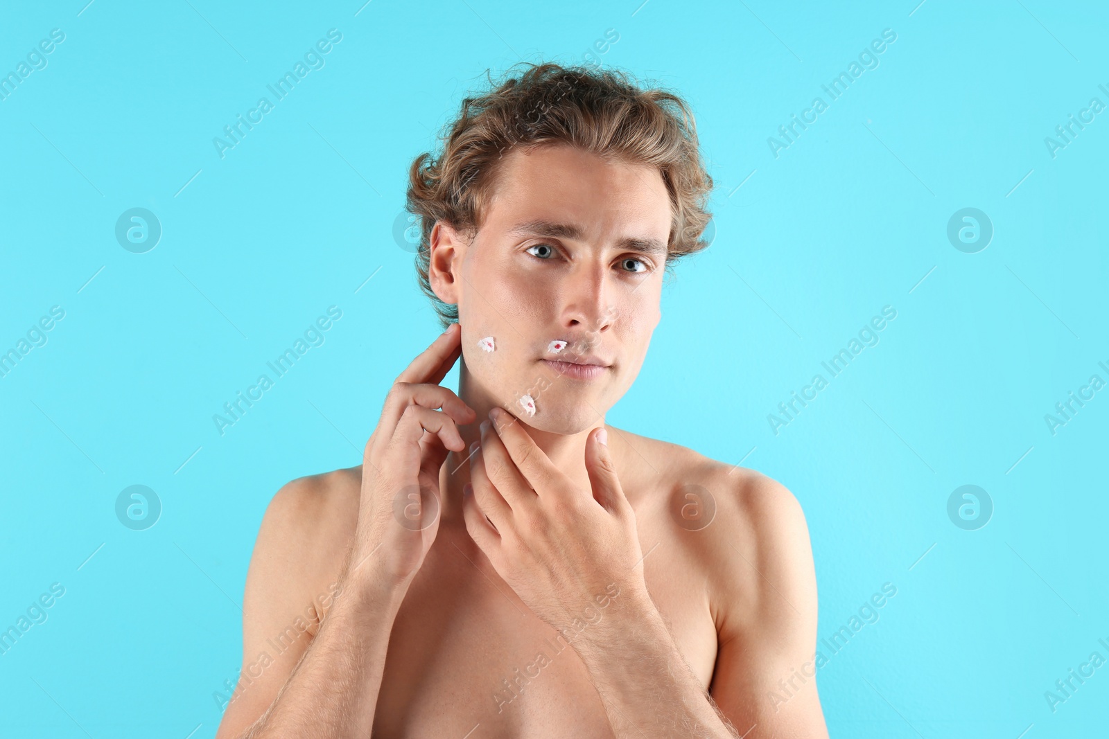 Photo of Young man with face hurt while shaving on color background