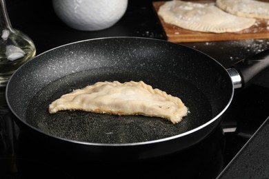 Cooking chebureki with tasty filling in frying pan