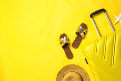 Photo of Flat lay composition with suitcase and beach accessories on color background. Space for text