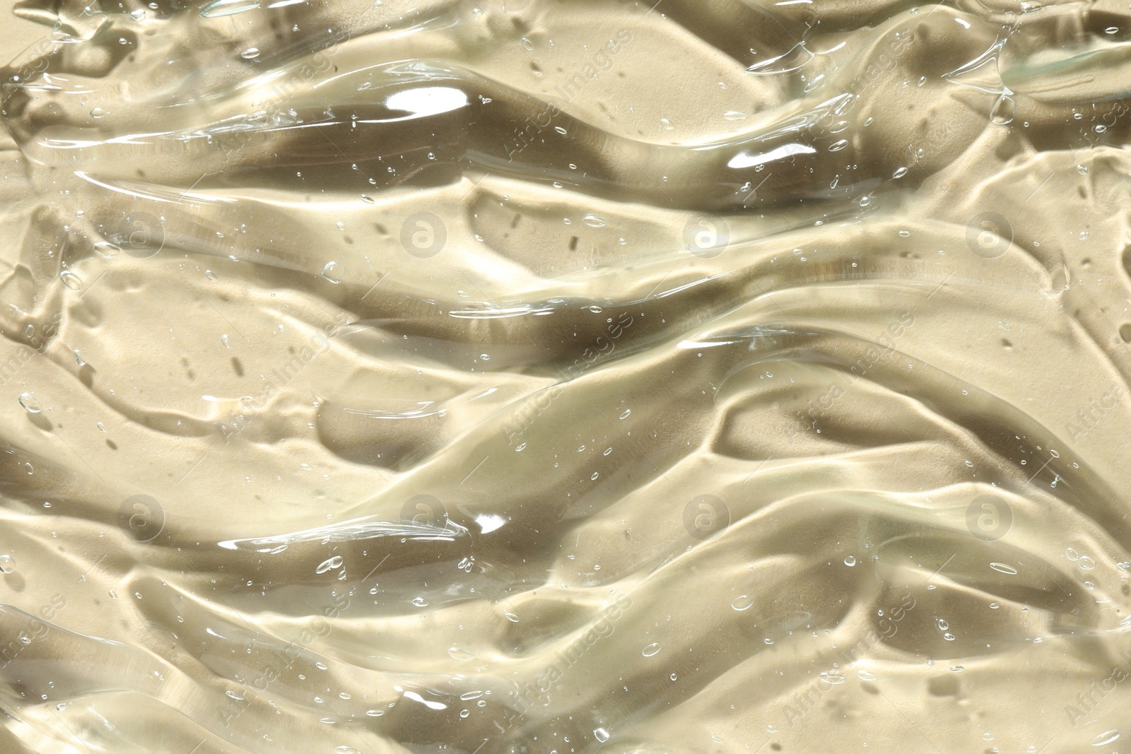 Photo of Clear cosmetic gel on beige background, closeup