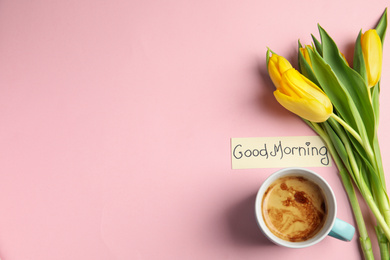 Photo of Delicious coffee, beautiful flowers and card with GOOD MORNING wish on pink background, flat lay. Space for text
