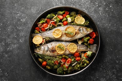 Photo of Baked fish with vegetables, rosemary and lemon on black textured table, top view