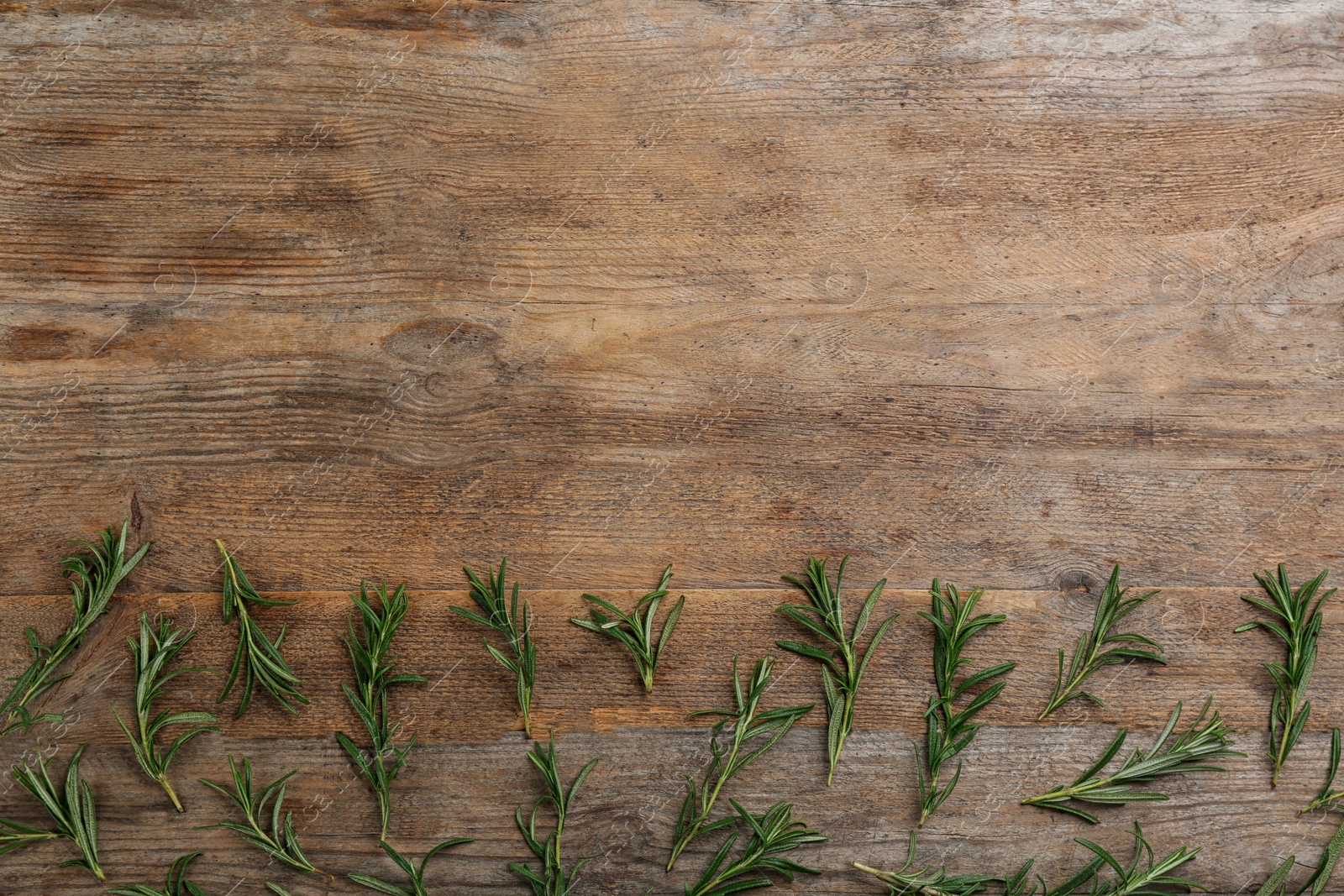 Photo of Flat lay composition with fresh rosemary on wooden table. Space for text