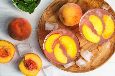 Photo of Tasty peach cocktail in glasses on table, top view. Refreshing drink