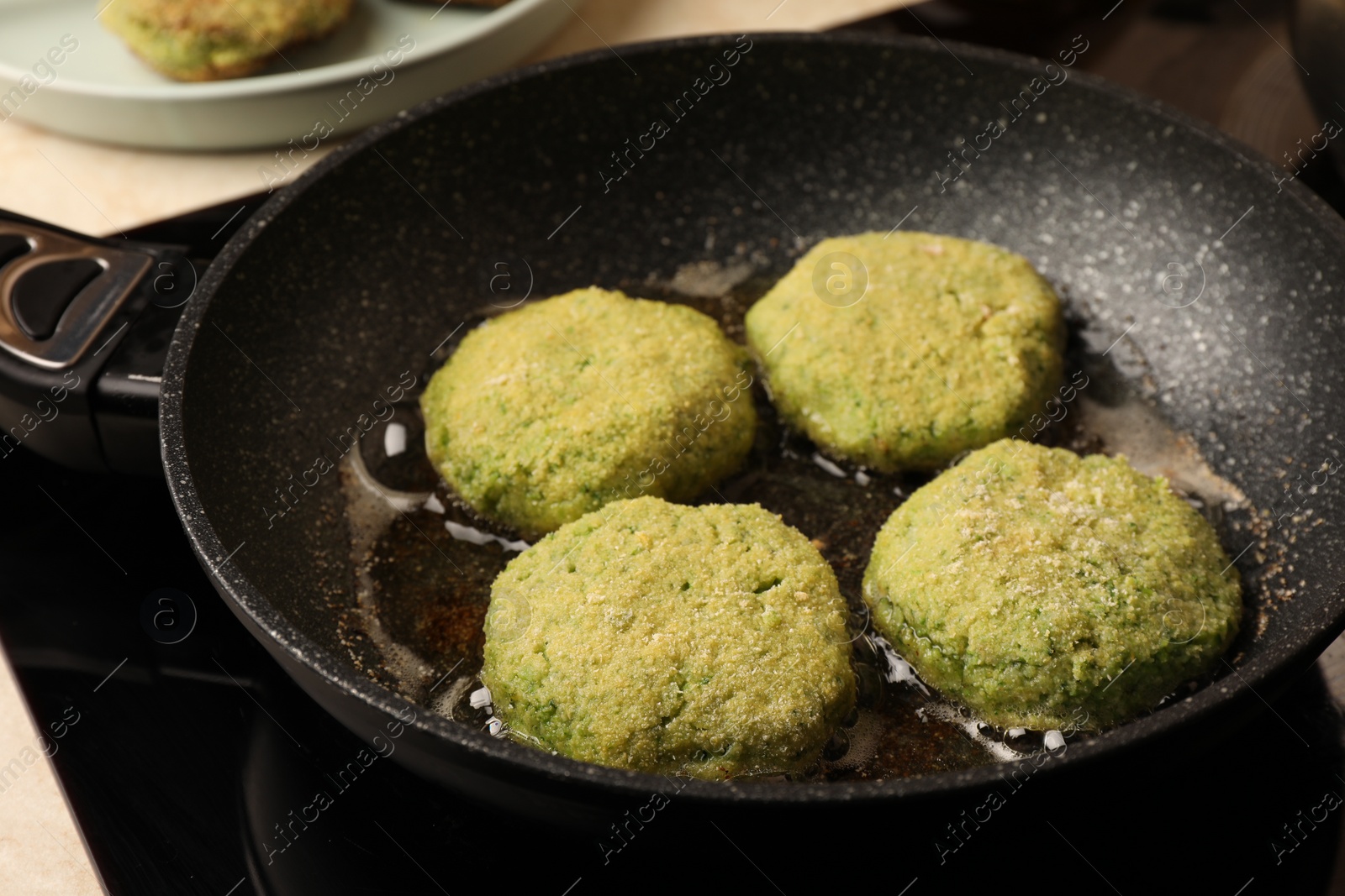 Photo of Cooking vegan cutlets in frying pan on stove, closeup