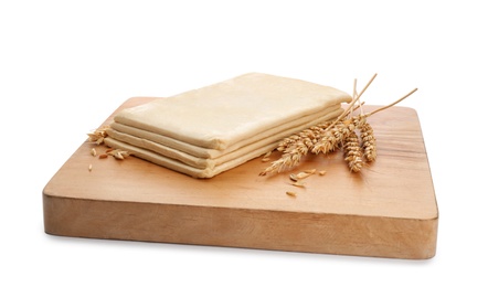 Photo of Wooden board with fresh dough on white background. Puff pastry