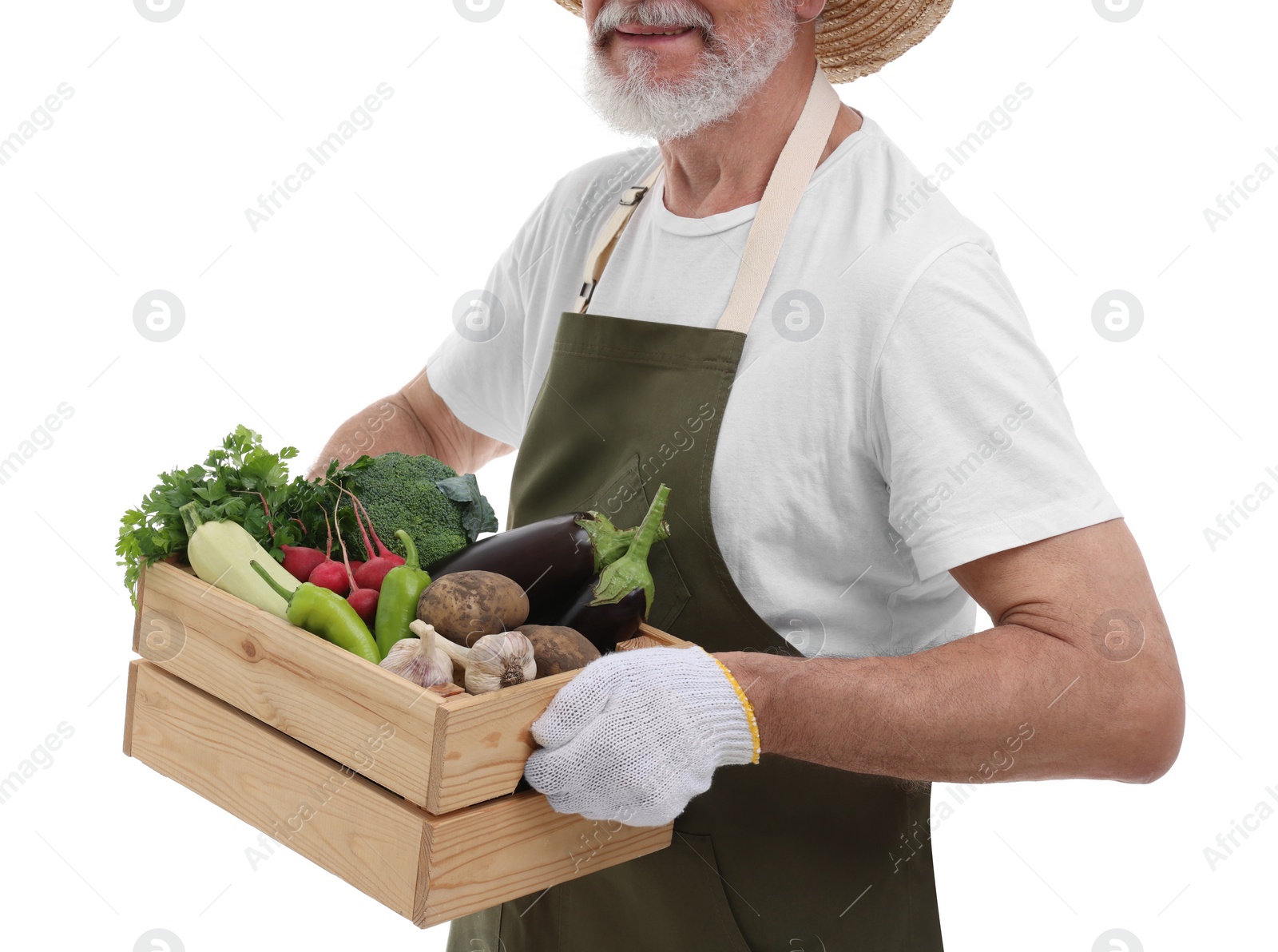 Photo of Harvesting season. Happy farmer holding wooden crate with vegetables on white background, closeup