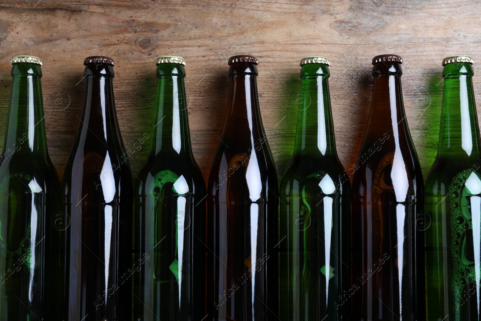 Photo of Bottles of beer on wooden table, flat lay