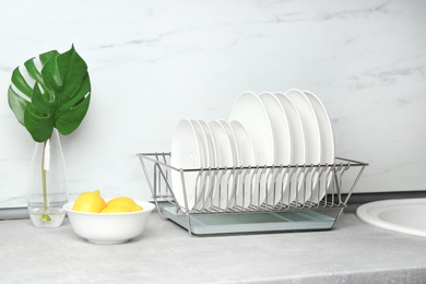 Different clean plates in dish drying rack on kitchen counter