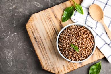 Photo of Flat lay composition with bowl of buckwheat porridge served on table. Space for text