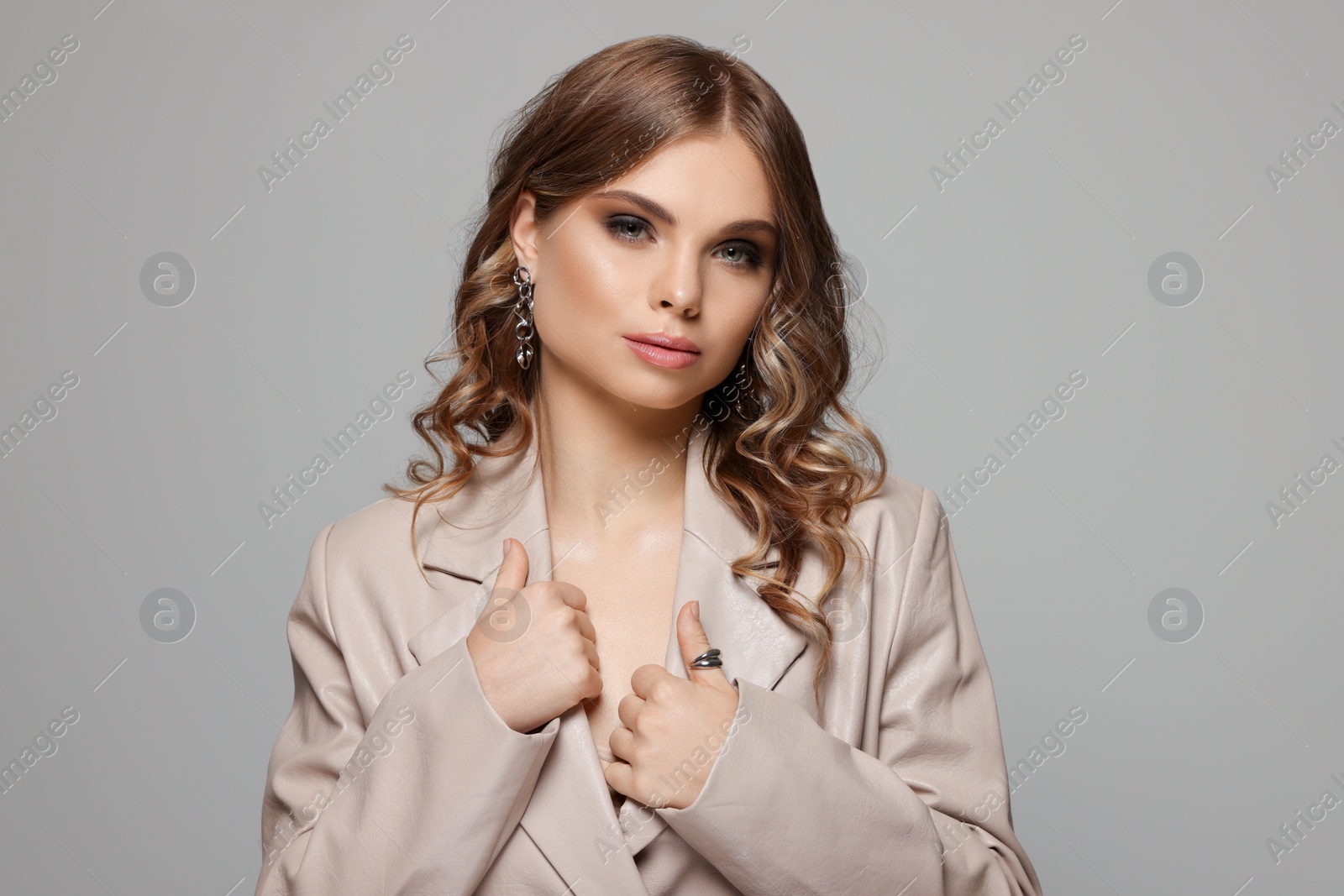 Photo of Portrait of young woman with beautiful makeup on grey background