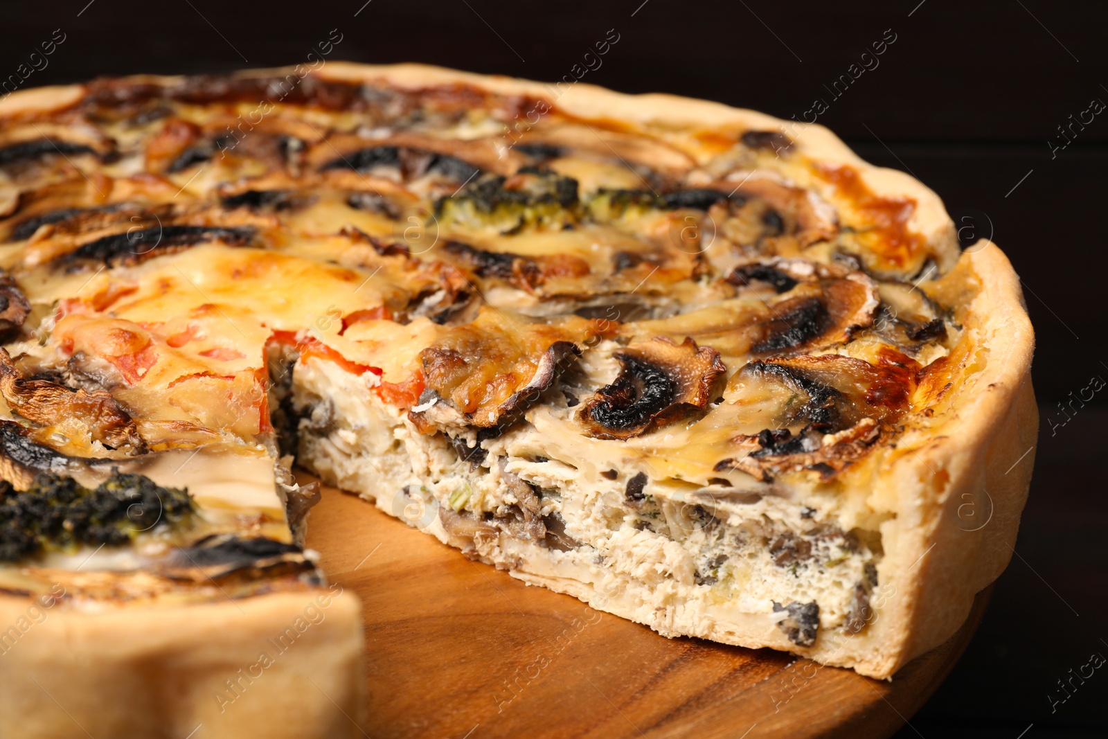 Photo of Delicious quiche with mushrooms on wooden table, closeup