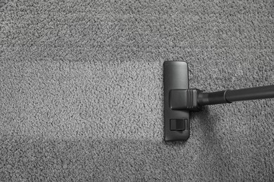 Photo of Vacuuming grey carpet. Clean area after using device, top view. Space for text
