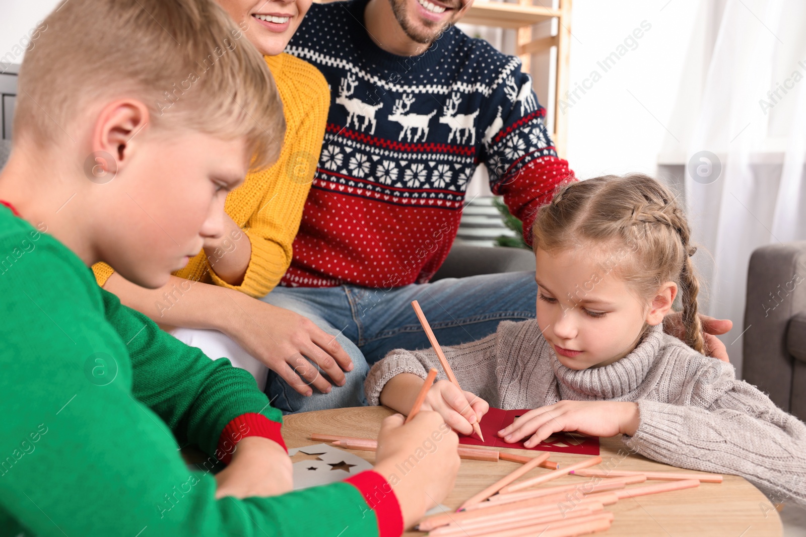 Photo of Cute children with their parents making beautiful Christmas greeting cards at home