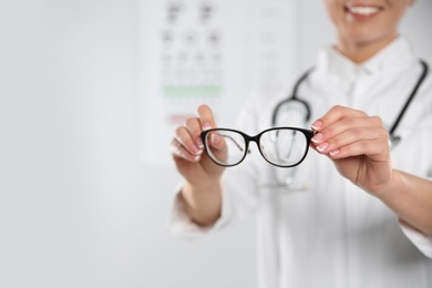 Photo of Female ophthalmologist with eyeglasses in clinic, closeup. Space for text