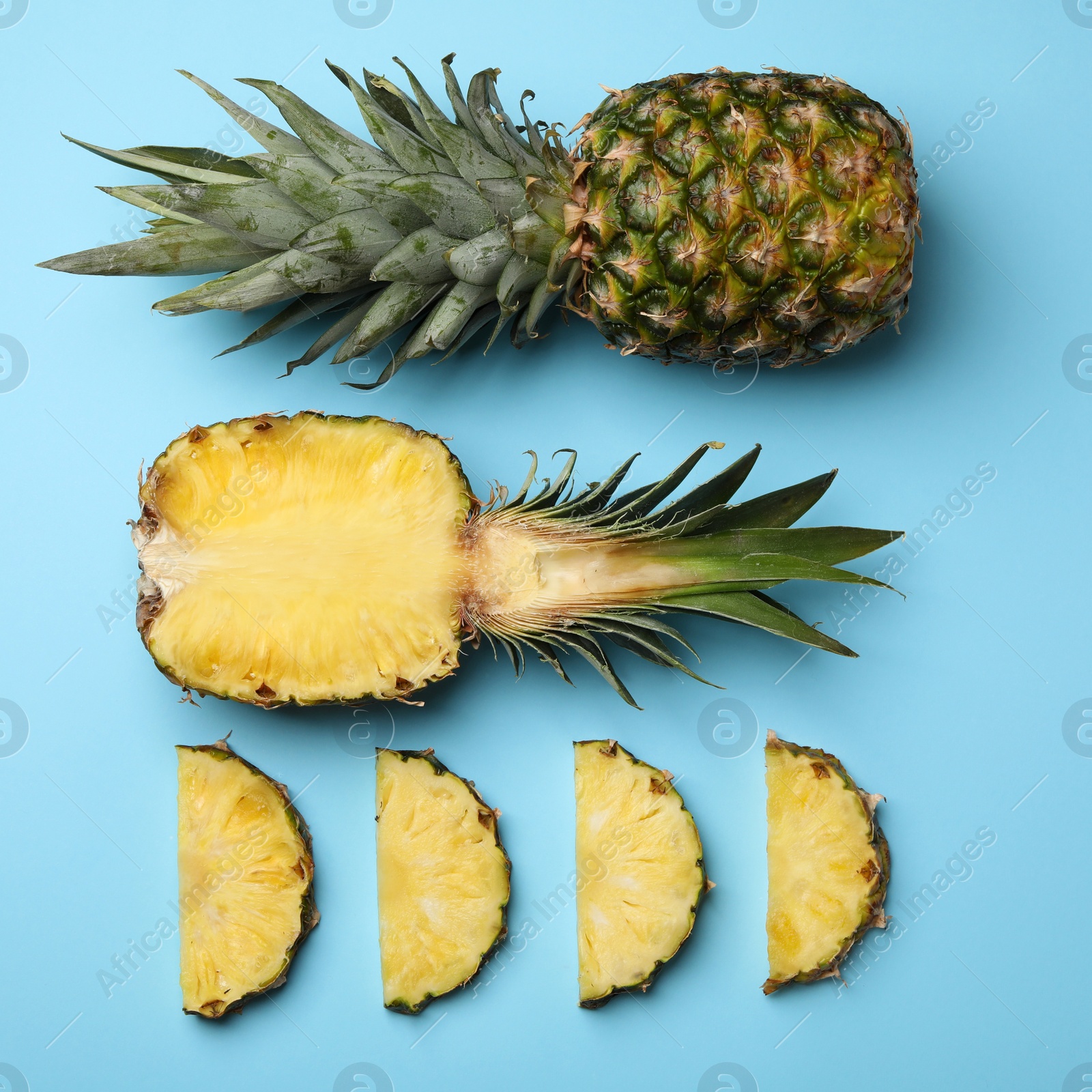 Photo of Flat lay composition with cut and fresh juicy pineapples on color background