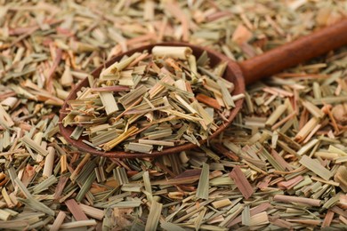 Photo of Wooden spoon and aromatic dried lemongrass, closeup