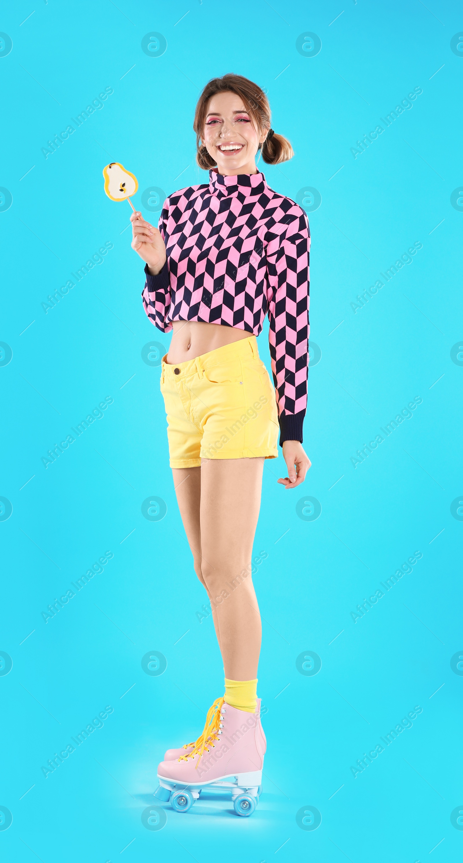 Photo of Young woman with lollipop and retro roller skates on color background