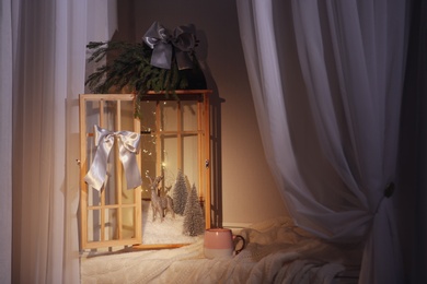 Photo of Vintage wooden lantern with beautiful Christmas composition on window sill indoors