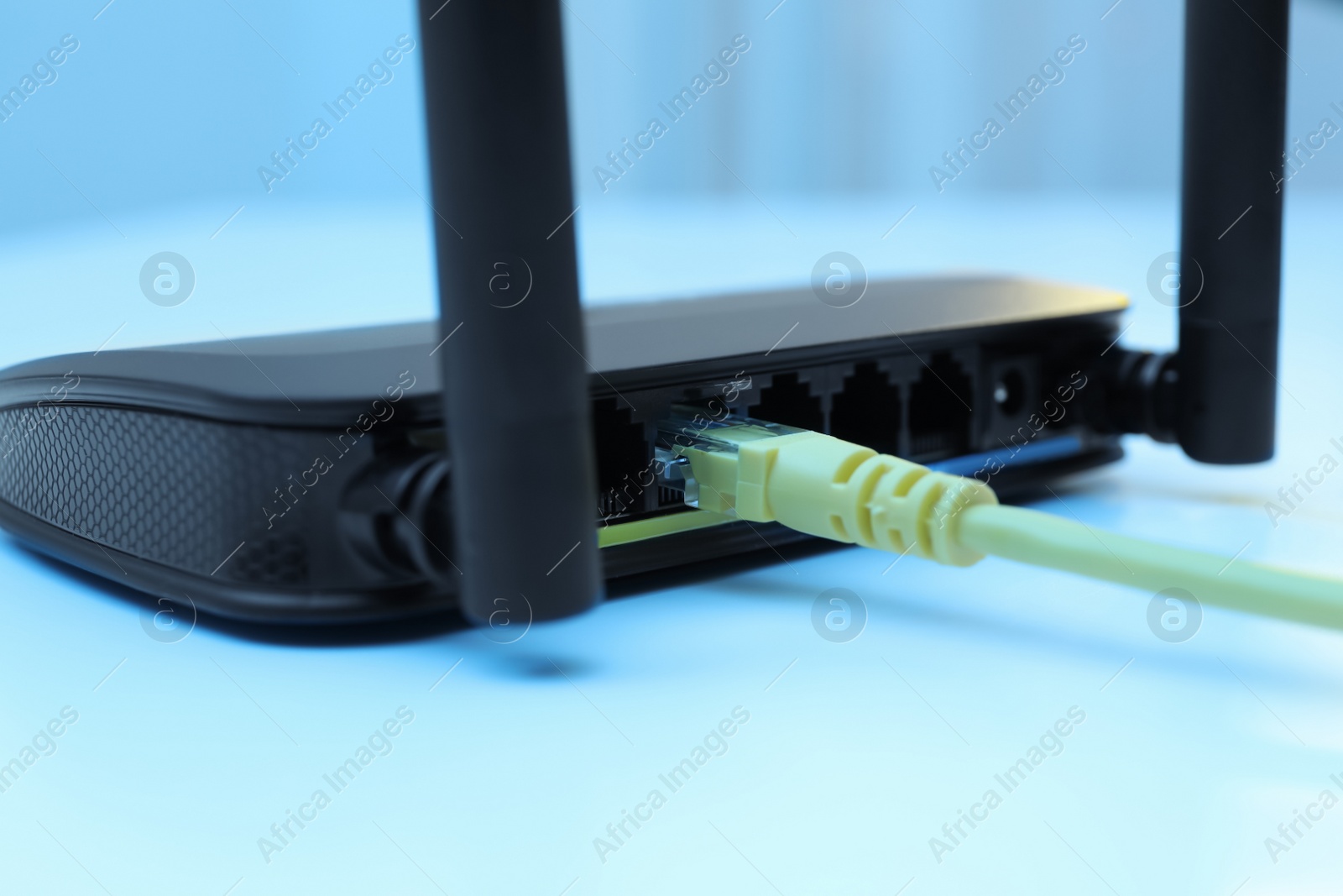 Photo of Connected cable to router on white table, closeup. Wireless internet communication