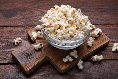 Photo of Bowl of tasty popcorn on wooden table