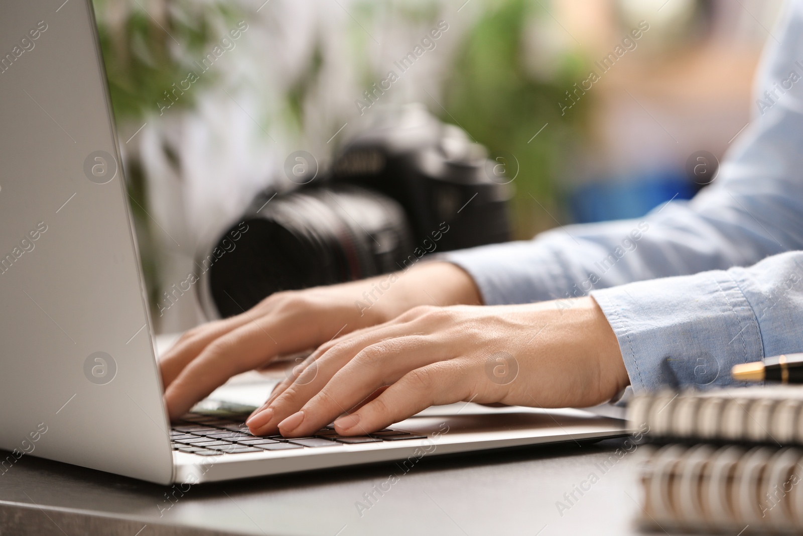 Photo of Journalist working with laptop at table, closeup