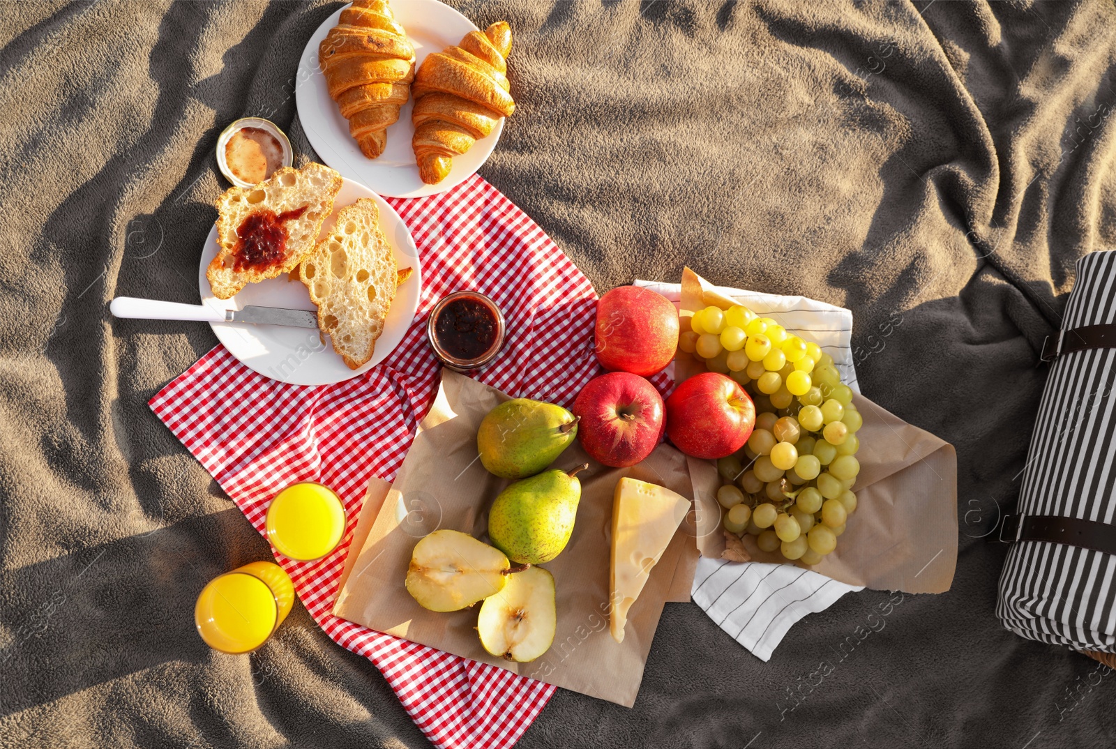 Photo of Picnic blanket with delicious food and juice outdoors on sunny day, top view