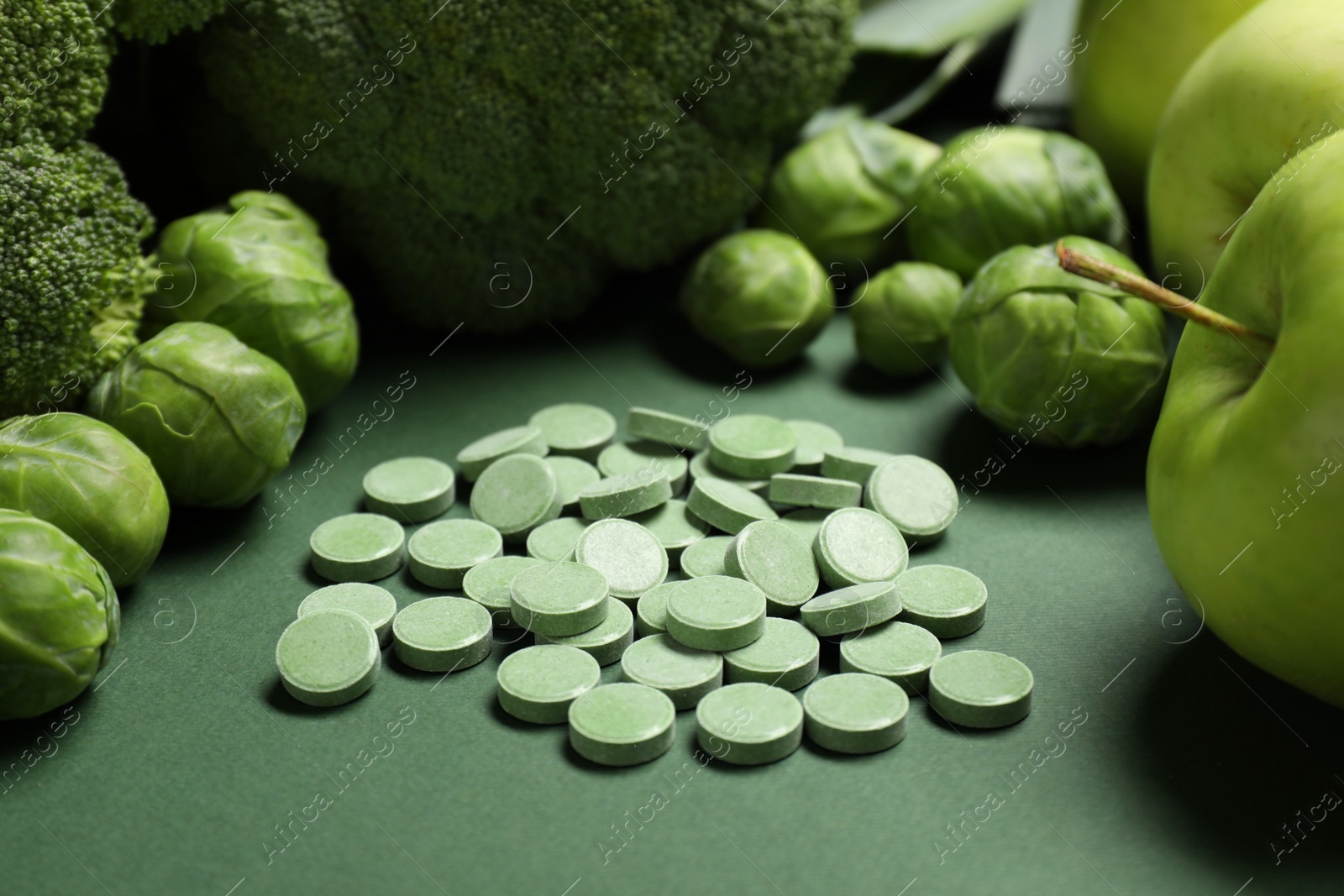 Photo of Pile of pills and food on green background. Prebiotic supplements