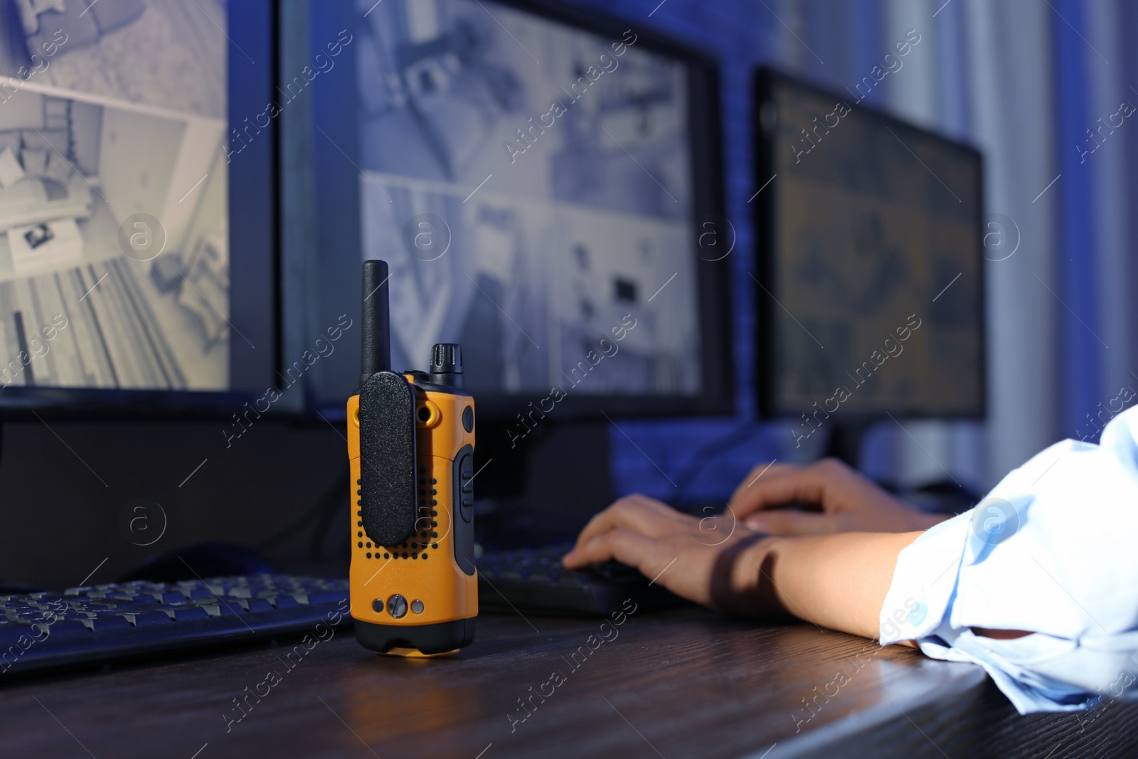 Photo of Female security guard with portable transmitter monitoring modern CCTV cameras indoors, closeup