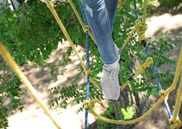 Photo of Child climbing in adventure park, closeup. Summer camp