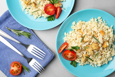 Delicious chicken risotto served on grey table, flat lay