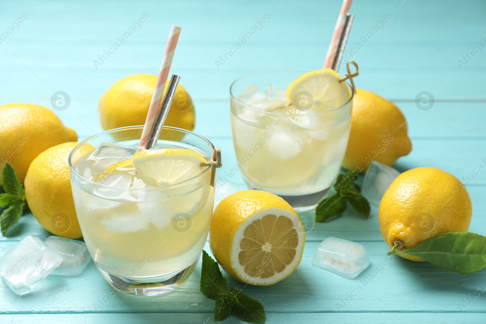 Photo of Natural lemonade and fresh fruits on light blue wooden table. Summer refreshing drink