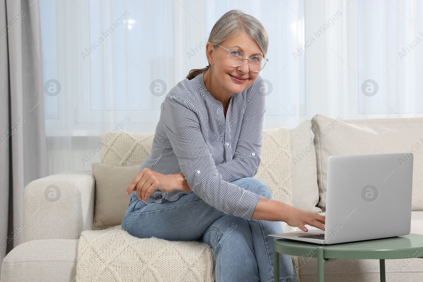 Photo of Beautiful senior woman using laptop at home