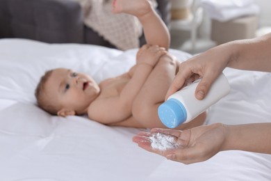 Photo of Mother with dusting powder near her baby at home, closeup