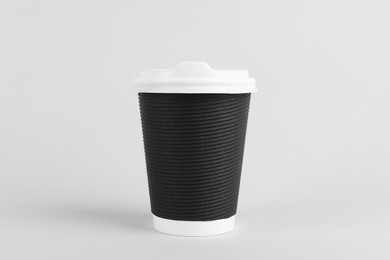 Photo of Black paper cup with plastic lid on light background. Coffee to go