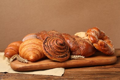 Different tasty freshly baked pastries on wooden table