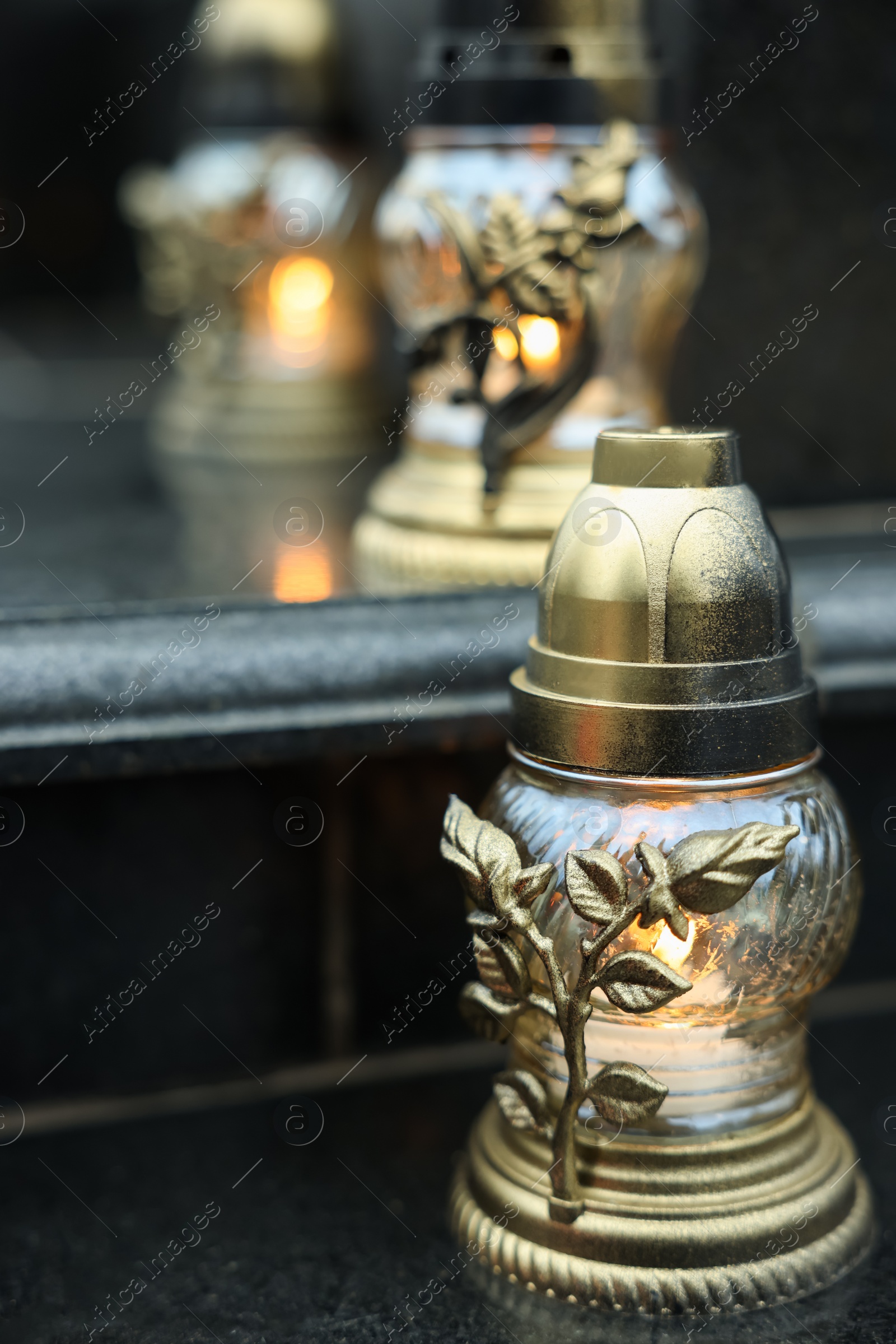 Photo of Grave lights on granite surface at cemetery